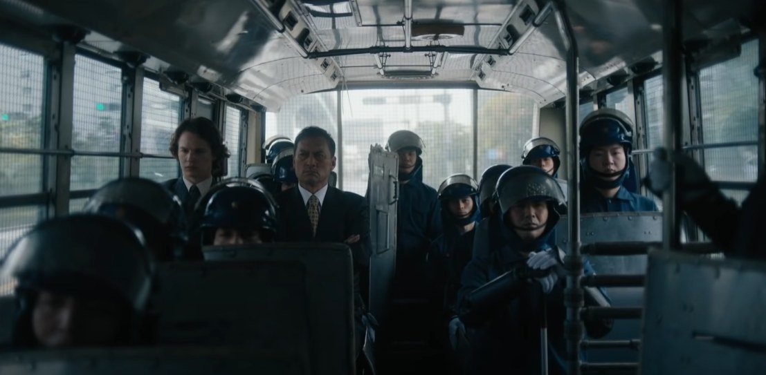 Ansel Elgort as Jake and Ken Watanabe as Detective Hiroto sitting in in a swat bus together