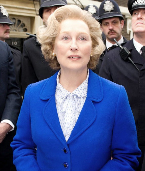 Meryl as Margaret in a suit with police officers behind her