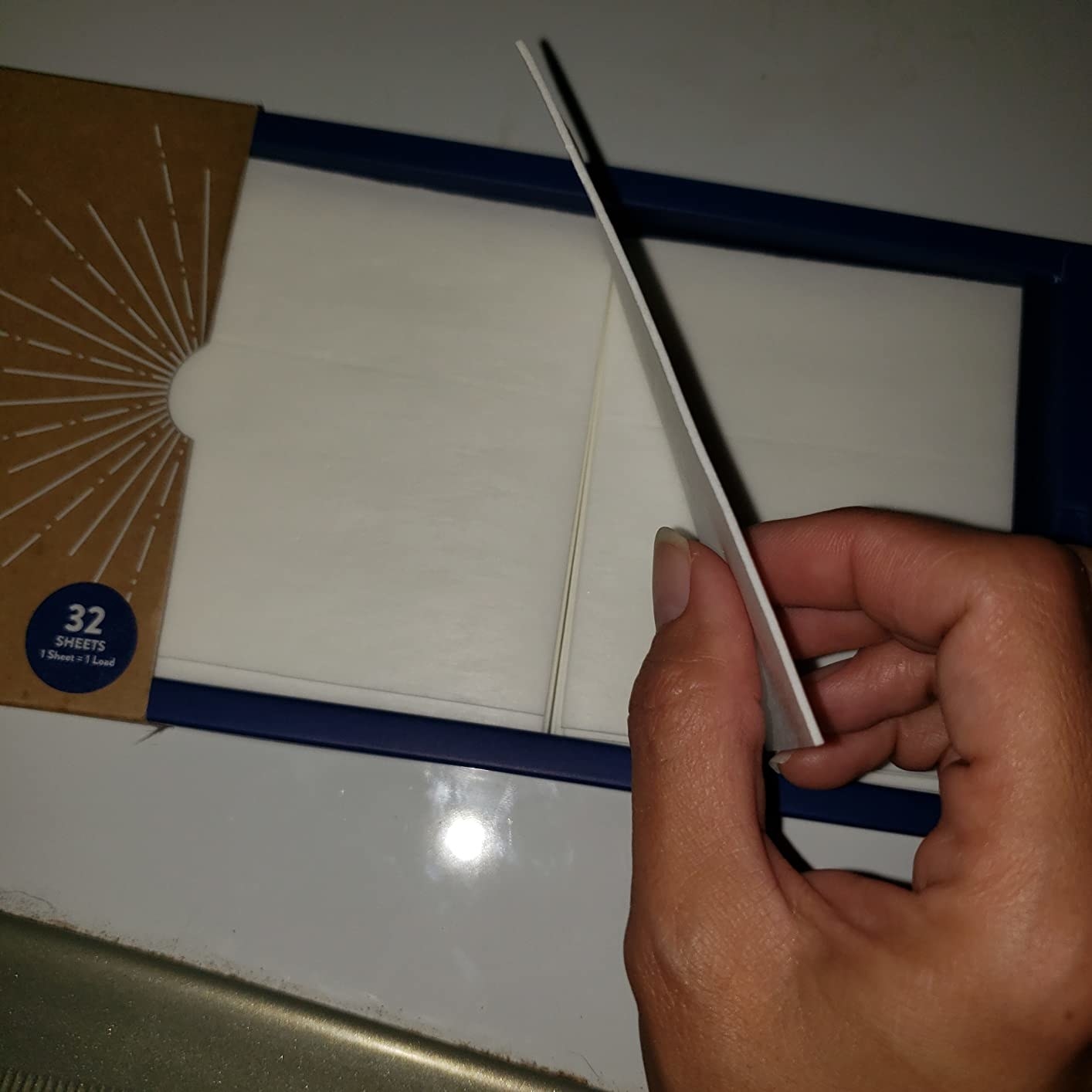 Reviewer pulling out one of the thin sheets from the box