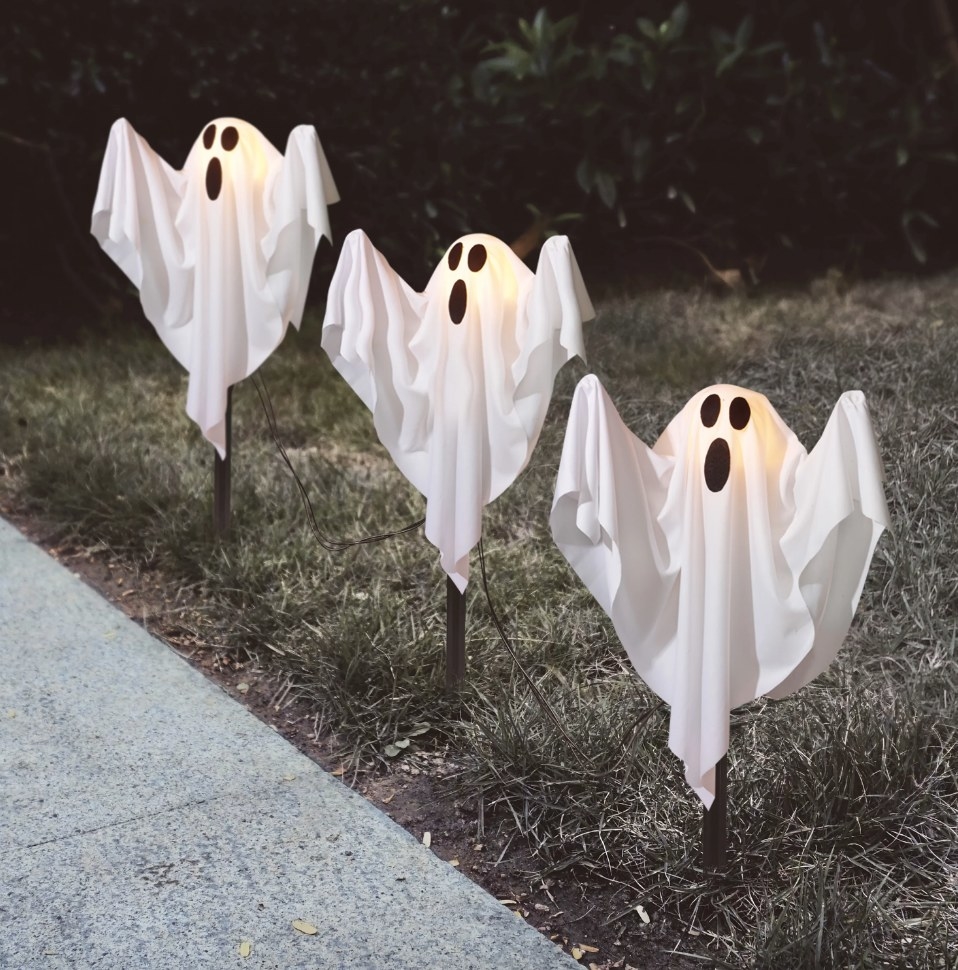 Three light-up white ghosts on lawn