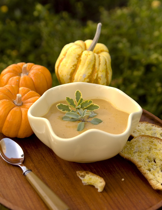 pumpkins around a bowl of pumpkin soup