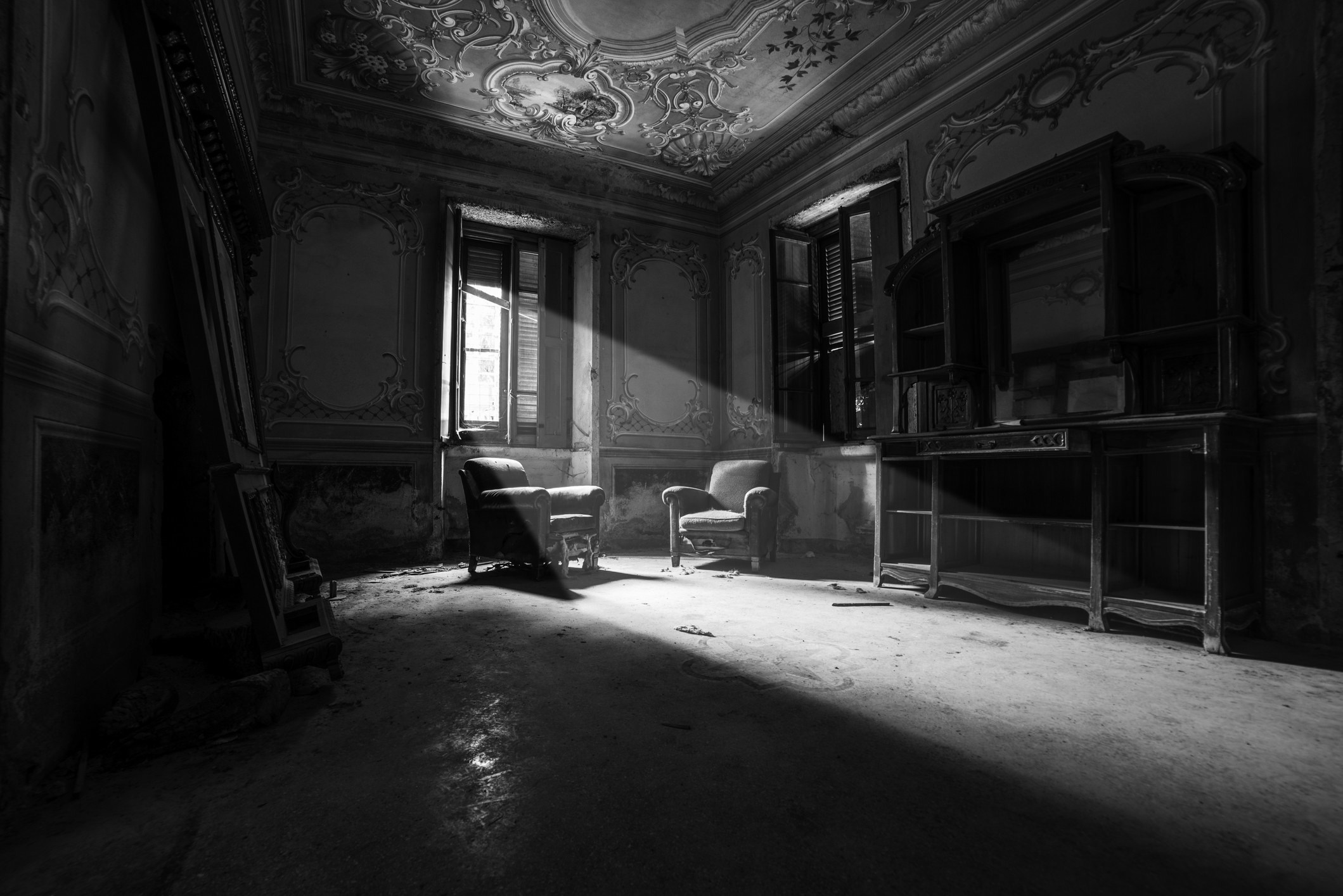a dark abandoned room with only a small bit of light coming in from a window