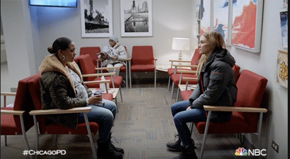 Two women talking in an emergency room waiting area