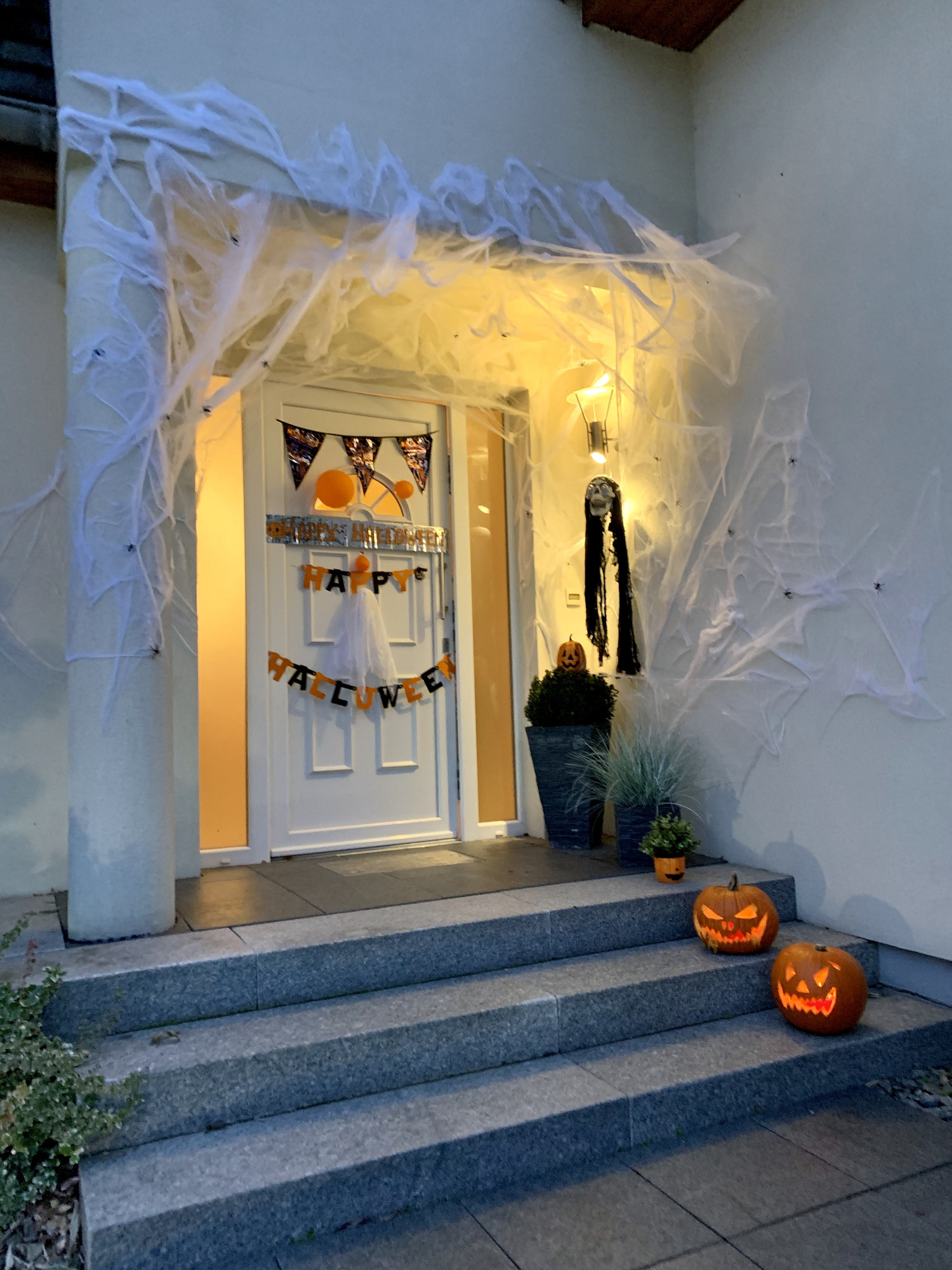 front door with pumpkins and fake cobwebs