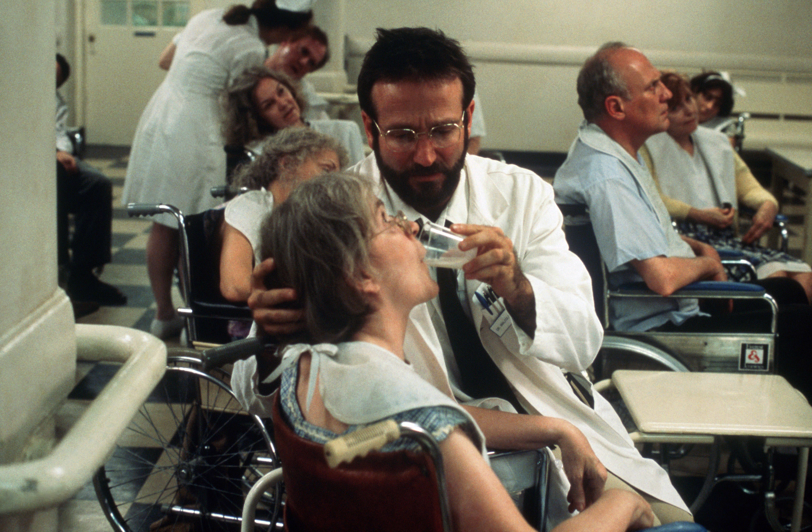 Robin helping a patient in a wheelchair in the movie