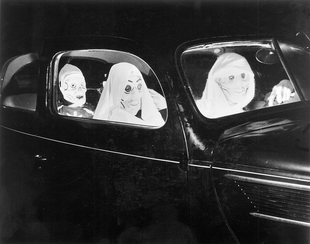 People in costume in a car