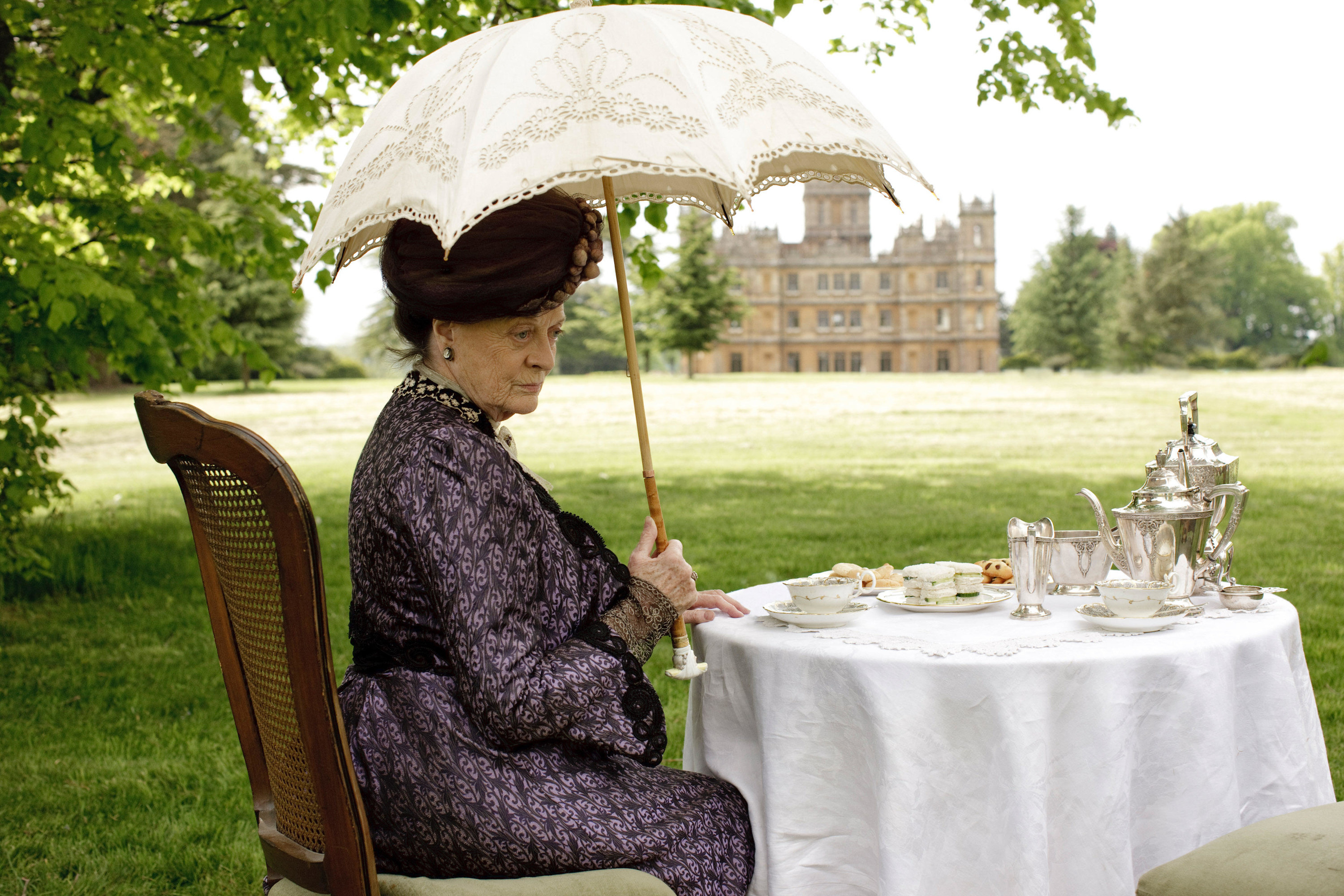 An old woman has lunch outside of a castle estate