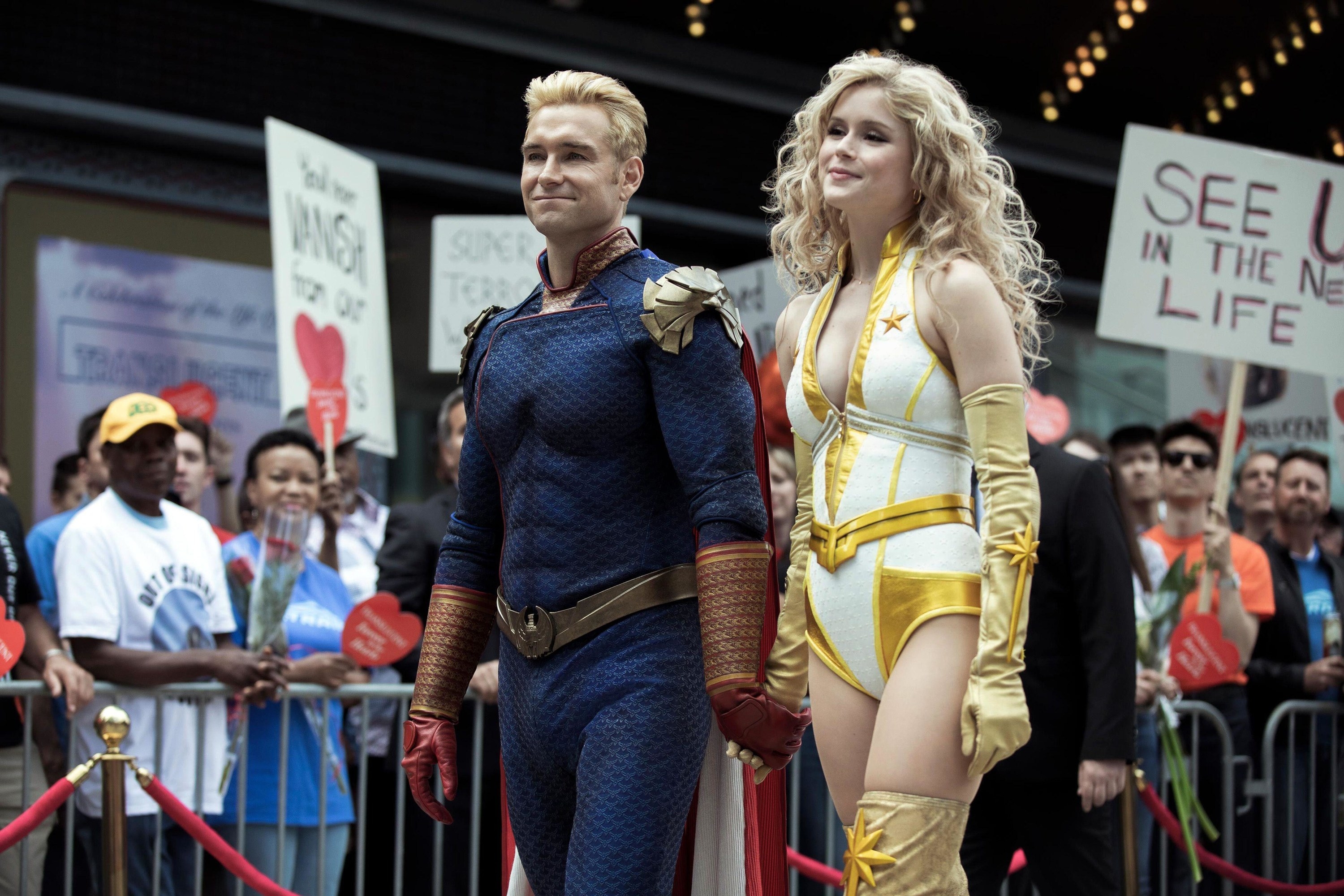 Two superheroes publicly hold hands while walking to an anticipated event