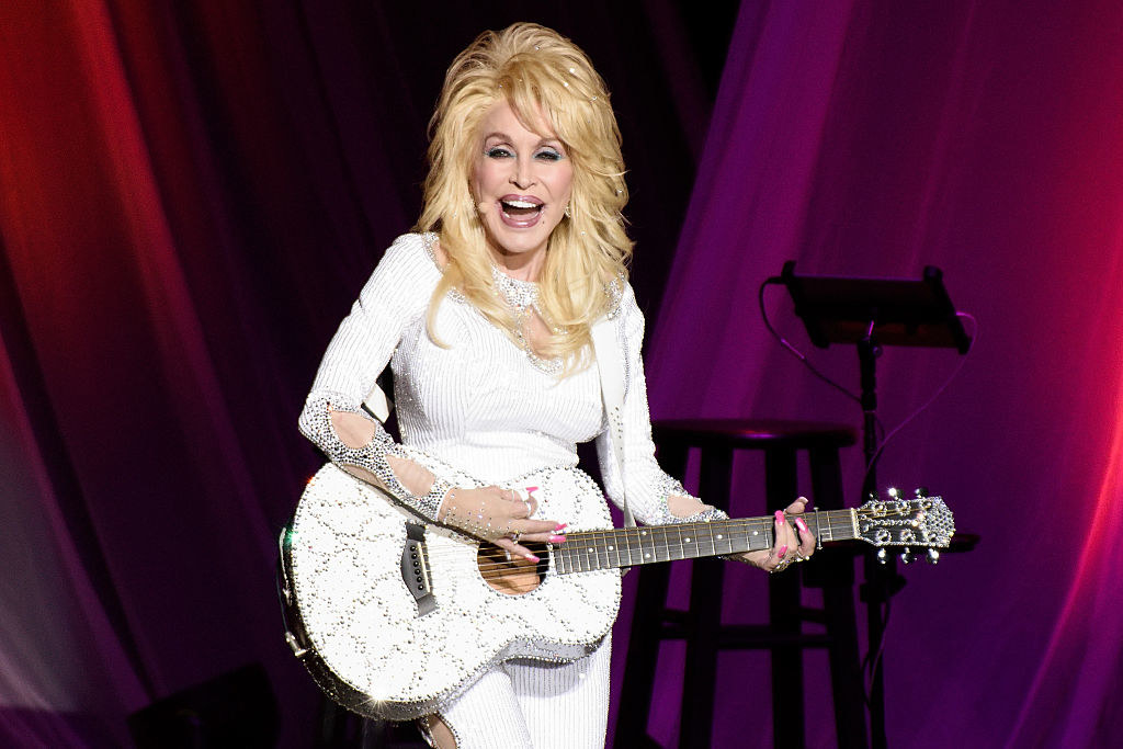 Dolly Parton playing a guitar