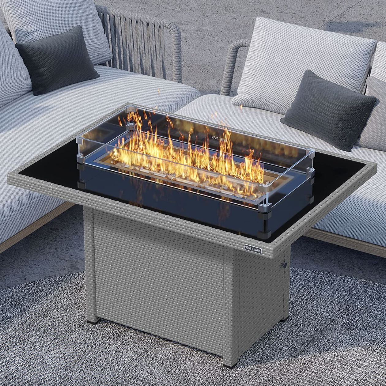 The gray firepit with a glass top and fire on top