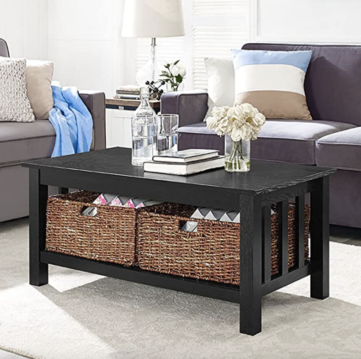 The black coffee table with two wicker baskets in the bottom shelf