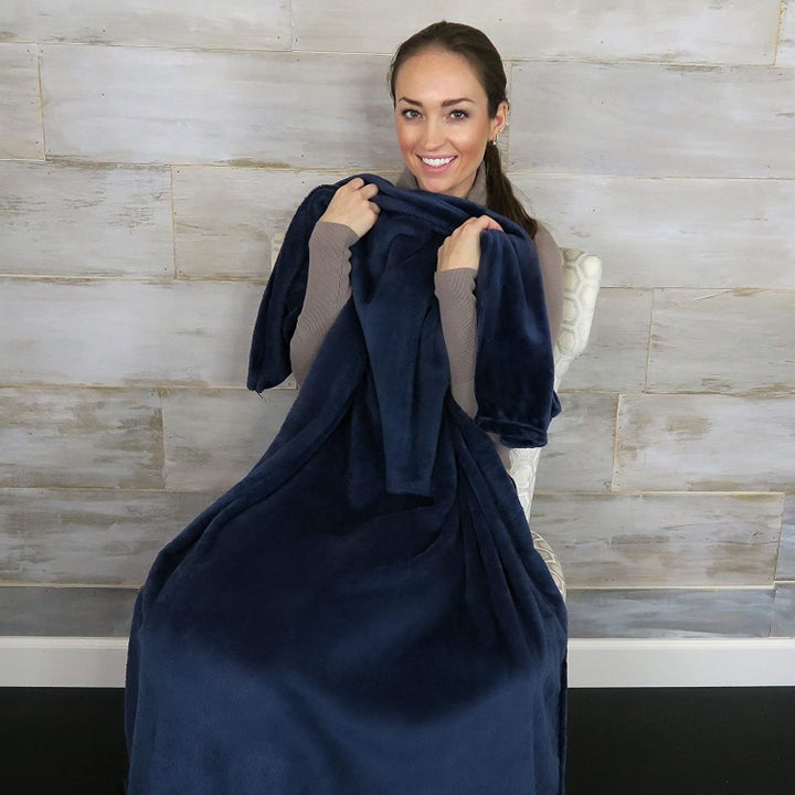 person sitting in a chair with the blanket over them