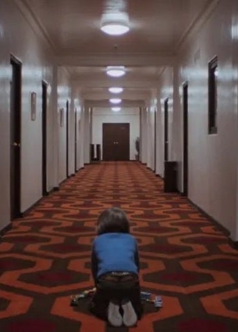 a young boy in the hallway of a hotel in &quot;the shining&quot;