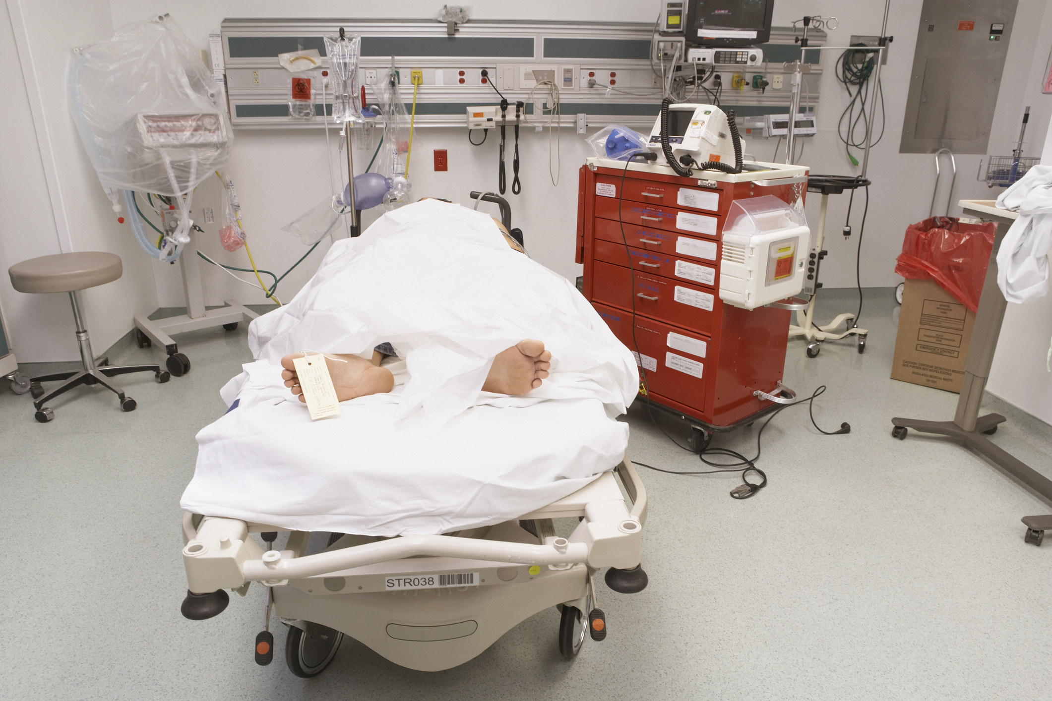 Corpse covered with a sheet lying on a hospital bed