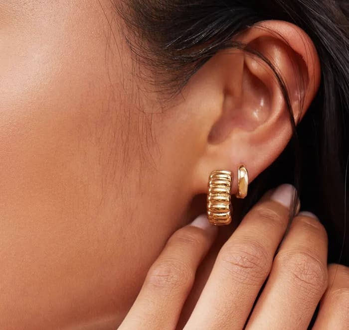 someone wearing the earrings in their first hole beside another earring in their second