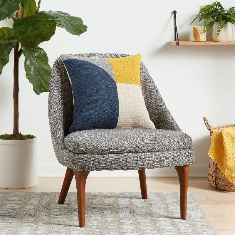 the blue, gray, yellow and beige pillow on a gray chair