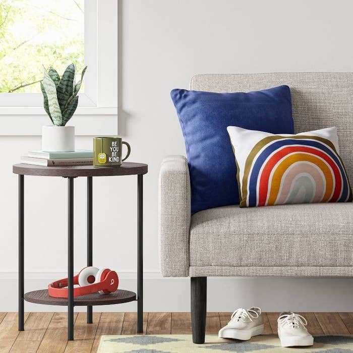 the dark brown end table next to a gray sofa