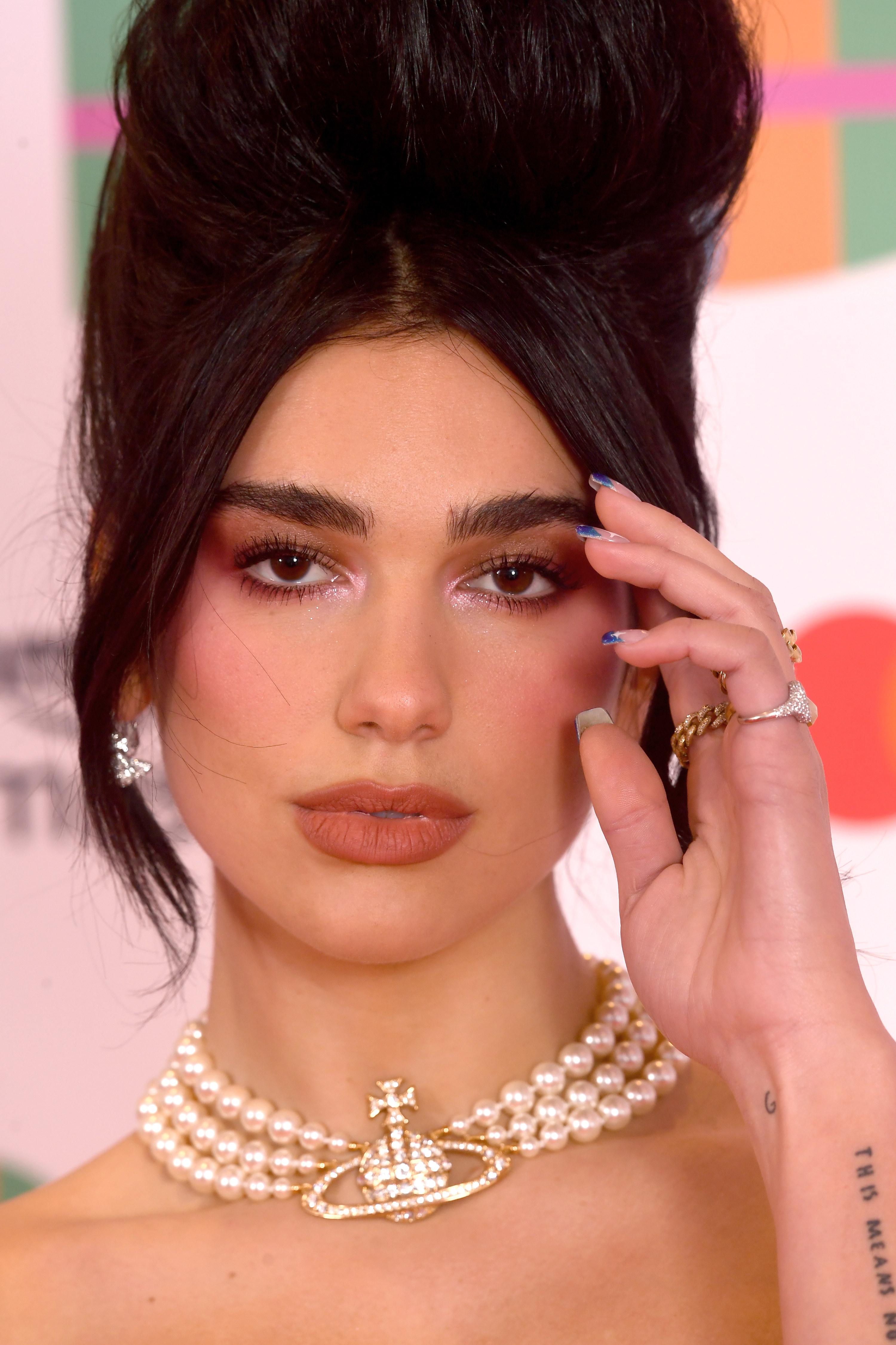 Close-up of Dua wearing a three-stand pearl choker and an updo