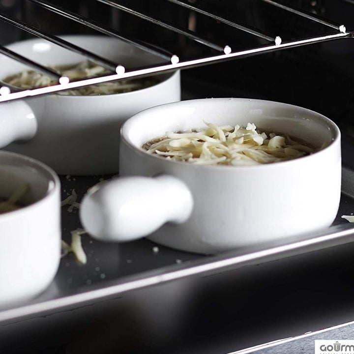 the onion soups with cheese sprinkled on top in the oven