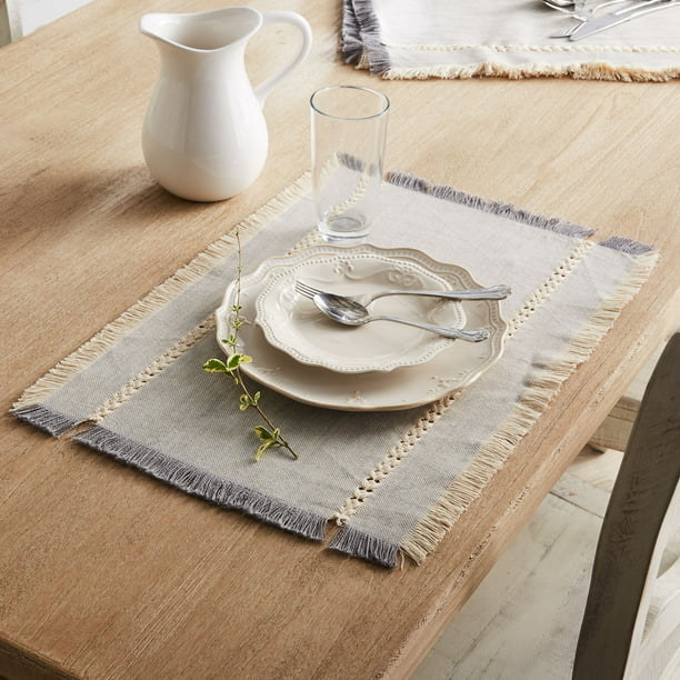 Gray placemat with white dinnerware on it