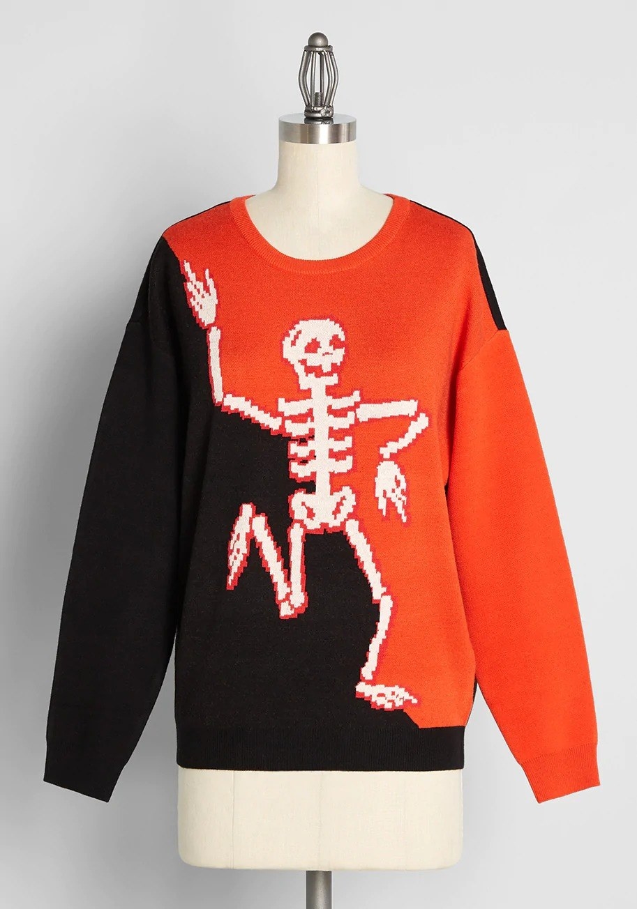 black and orange sweater with a skeleton dancing on the front