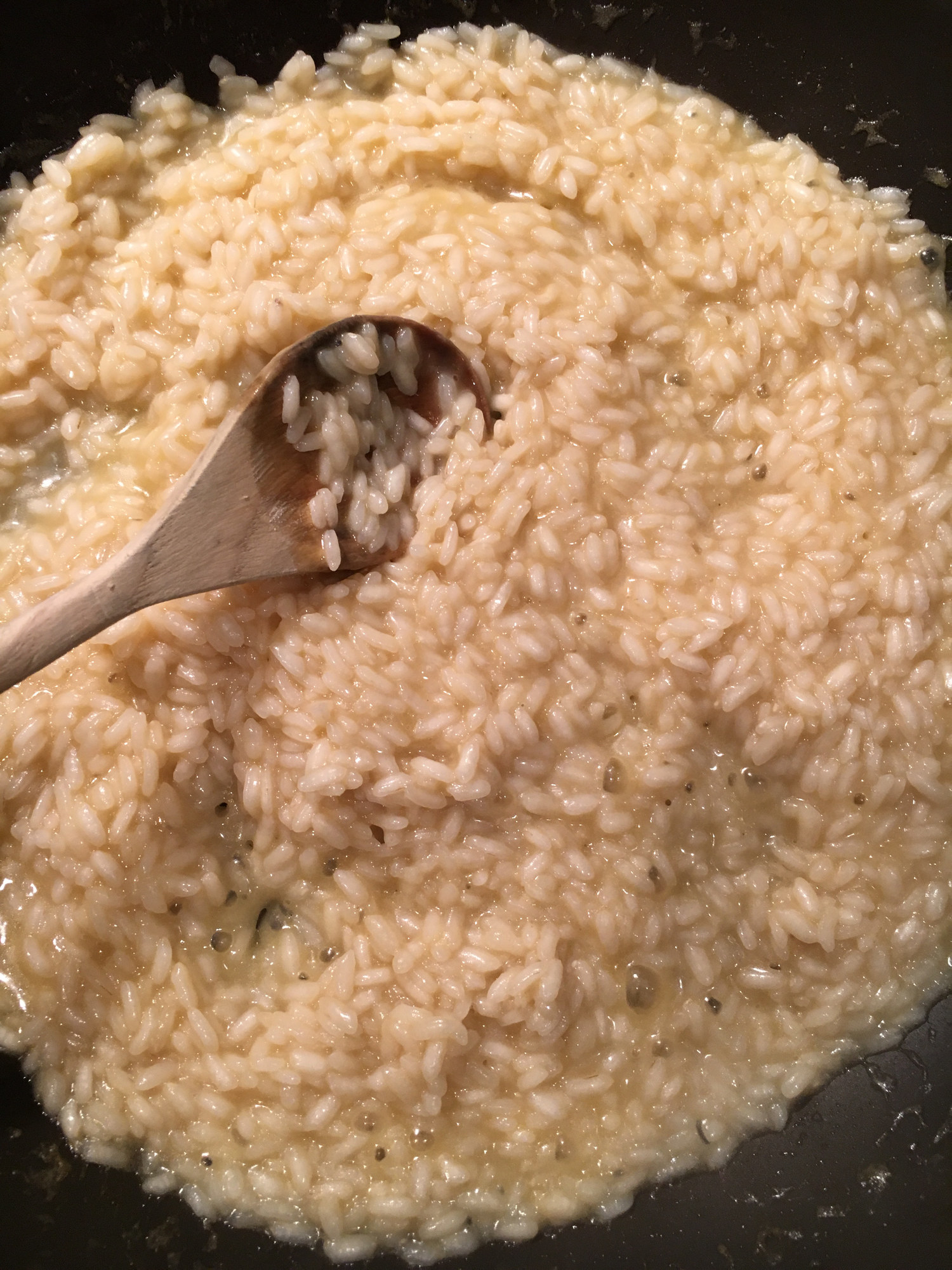 Cooking risotto stirred with a wooden spoon.
