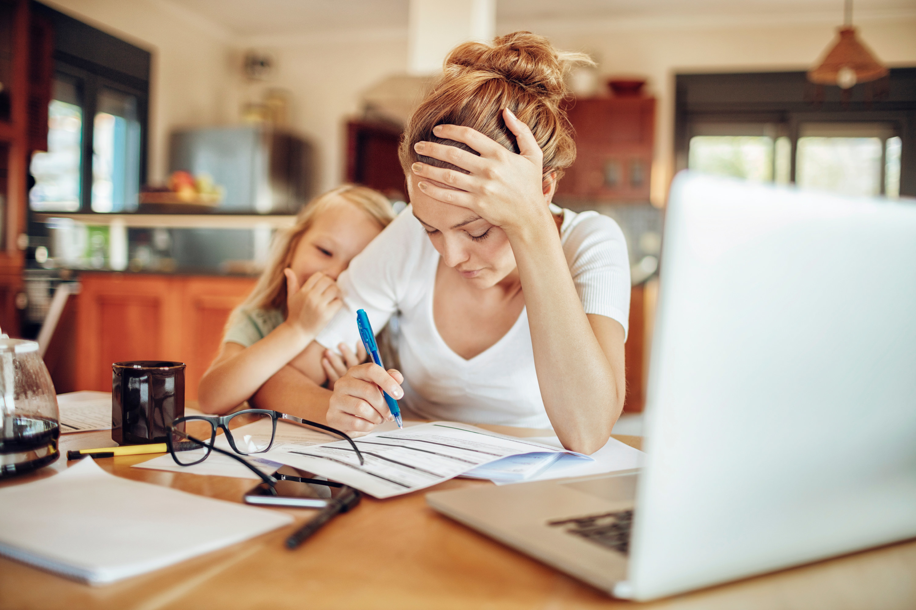A woman grows frustrated while her daughter distracts her from work