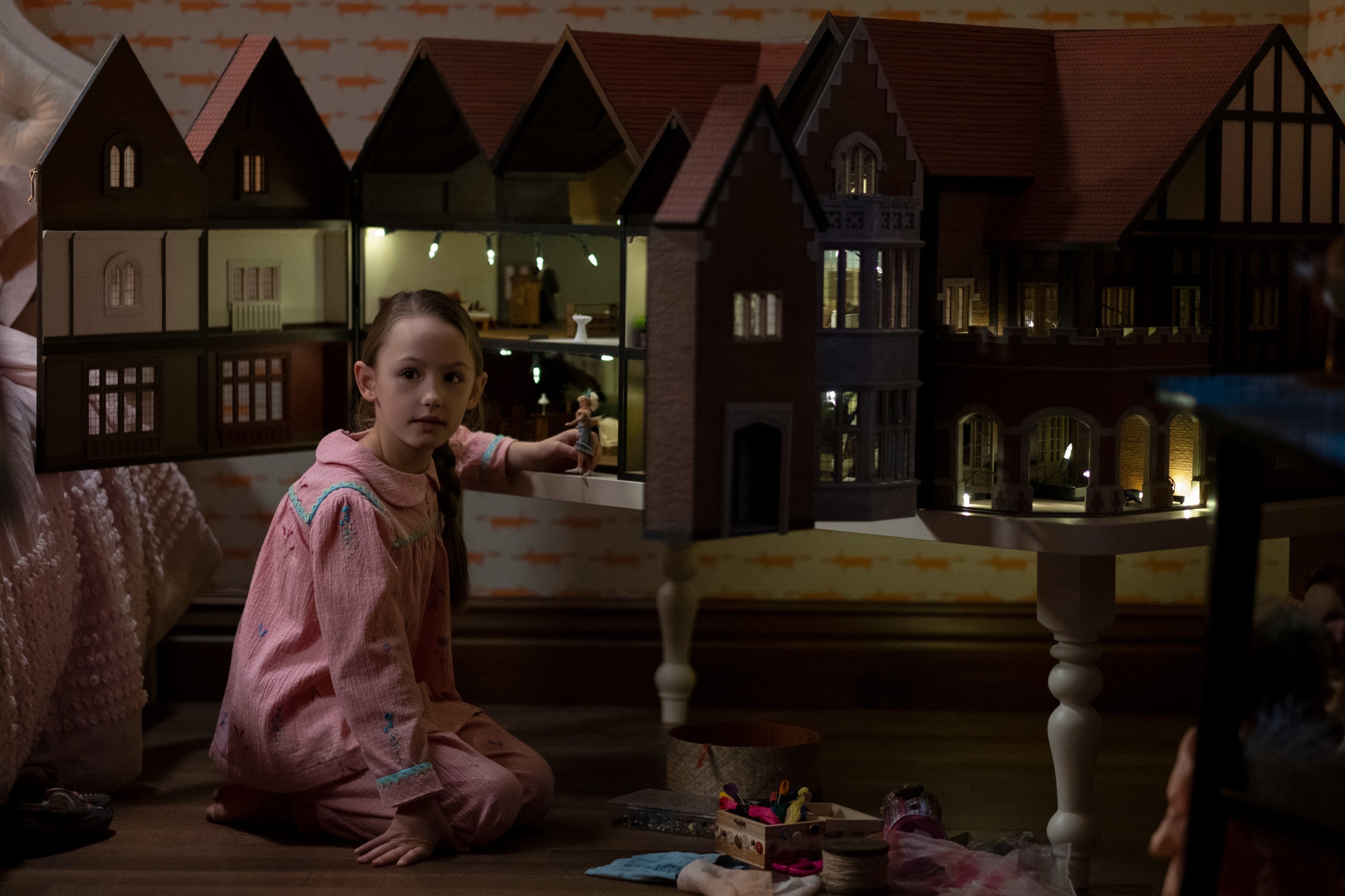 a girl playing with a dollhouse