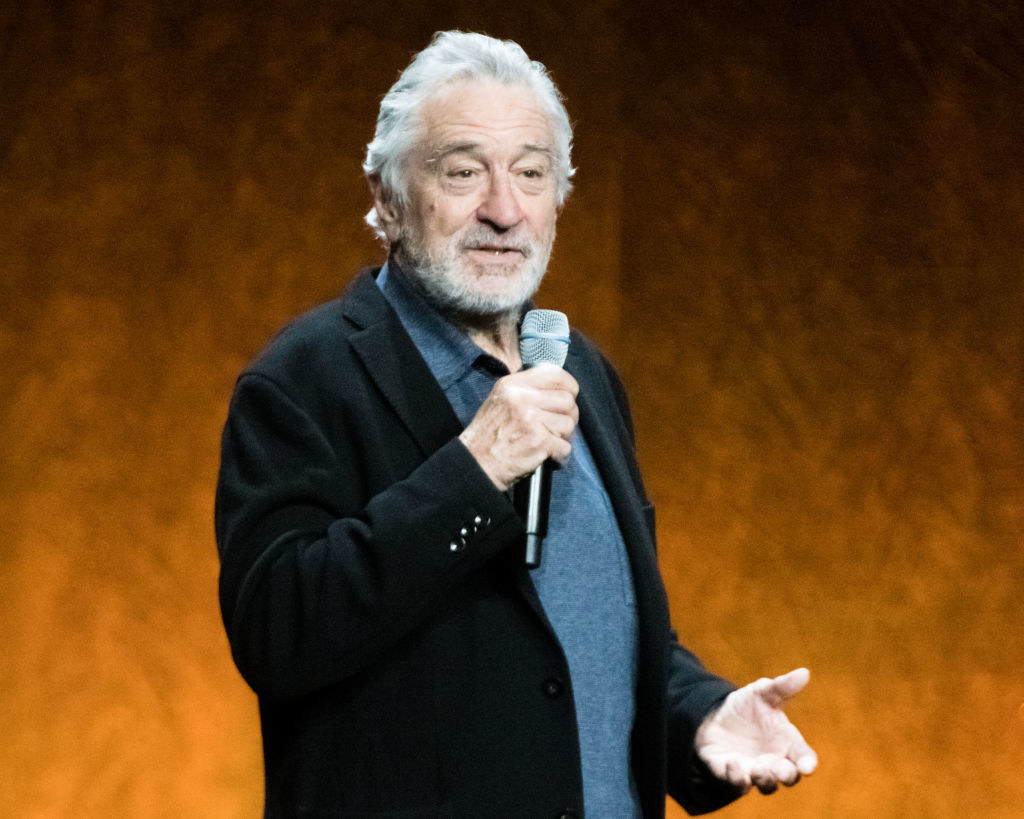 De Niro standing and holding a microphone