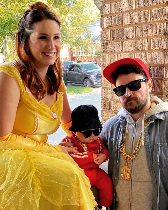a lady dressed as Belle and a man and baby dressed like the Beastie Boys