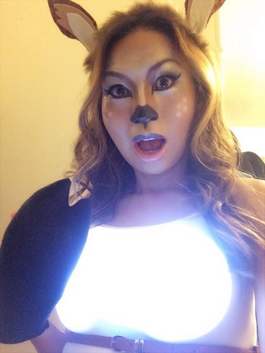 一个女人打扮成一只鹿与头灯在胸前