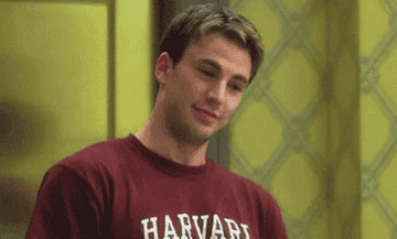 man in a Harvard shirt nodding and smiling