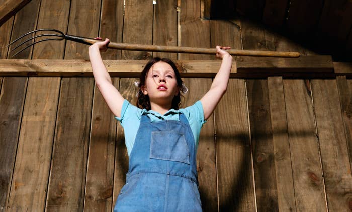 closeup of a young girl holding up of a large pitchfork