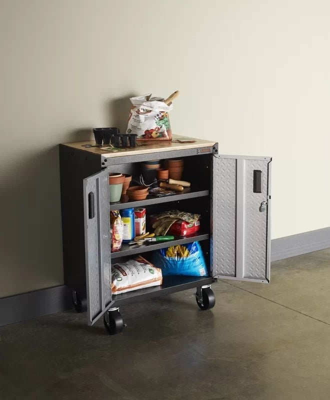 A grey steel storage unit with two shelves on wheels with a hardwood work top (not inlcluded)