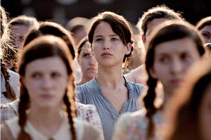 Katniss is standing in a crowd looking up