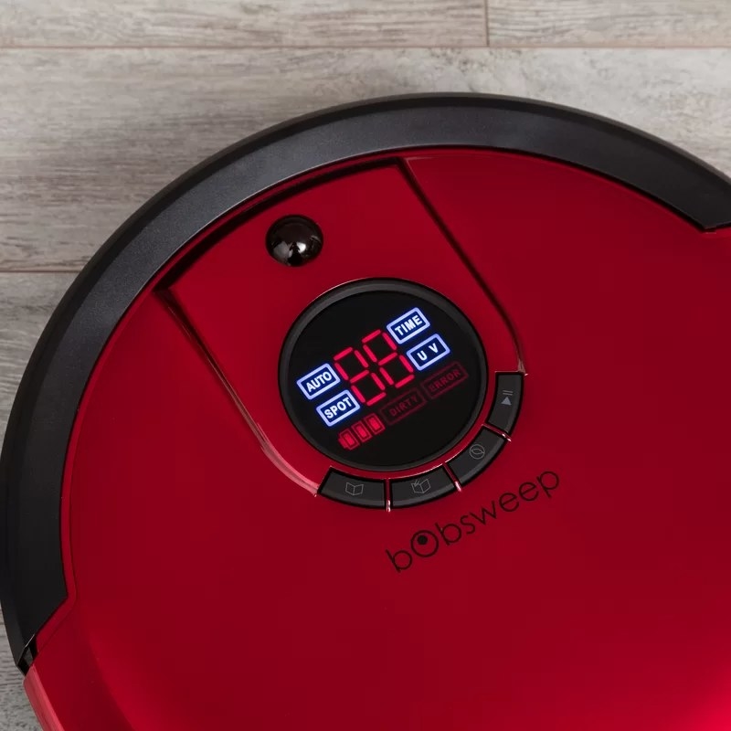 A red-colored bObsweep robotic vacuum on a hardwood floor
