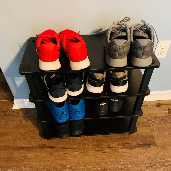 A black wooden shoe rack with 4 shelves