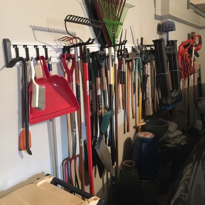 A GearTrack rack with multiple tools hanging from it