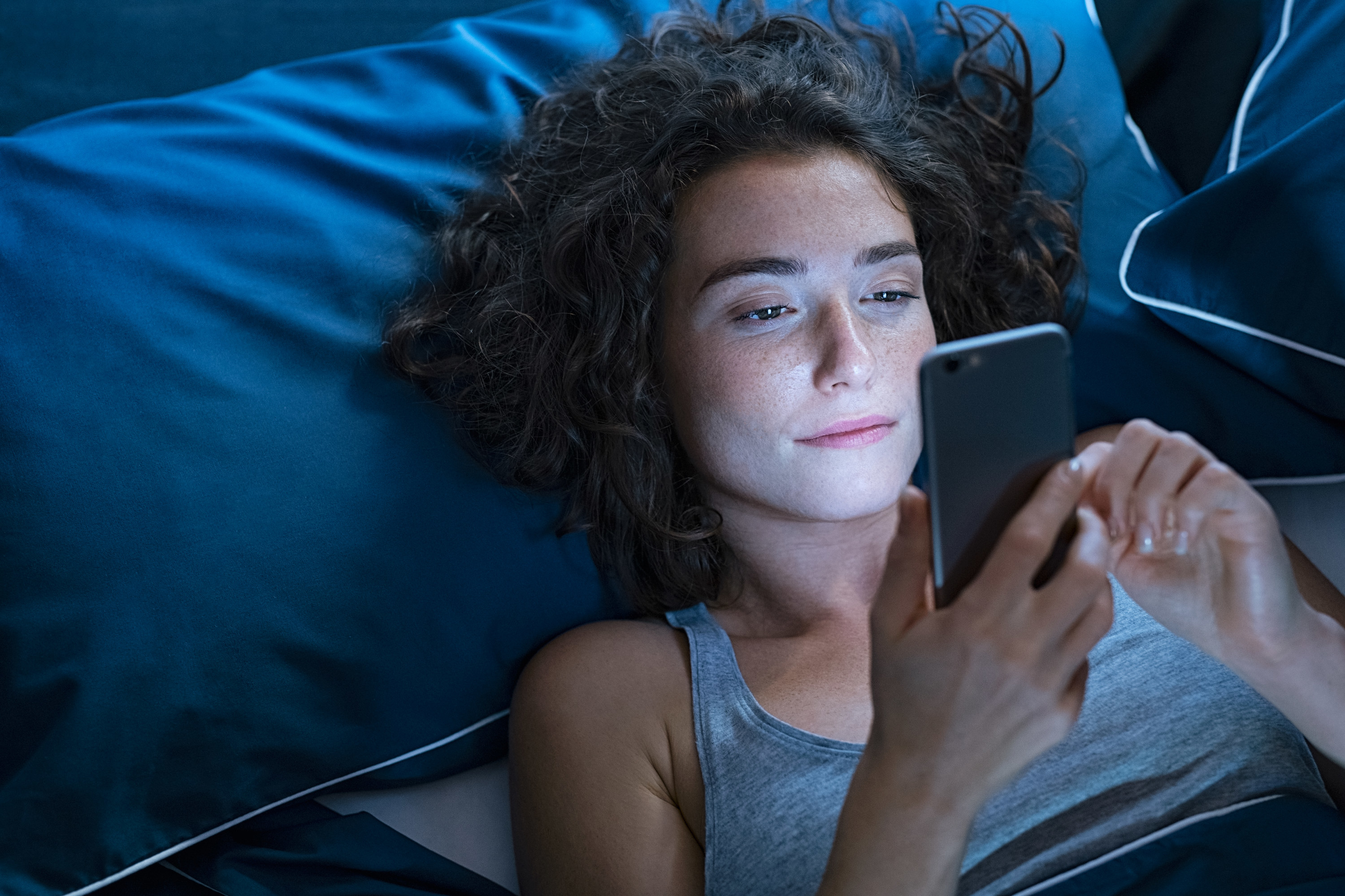 person using a phone in bed