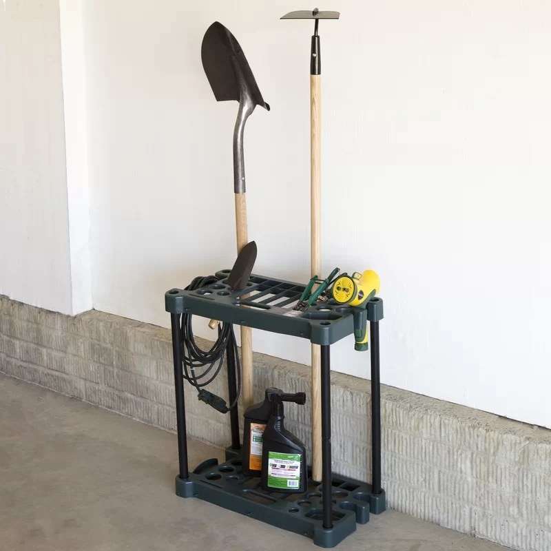 A tool rack holding a rake, shovel and other items