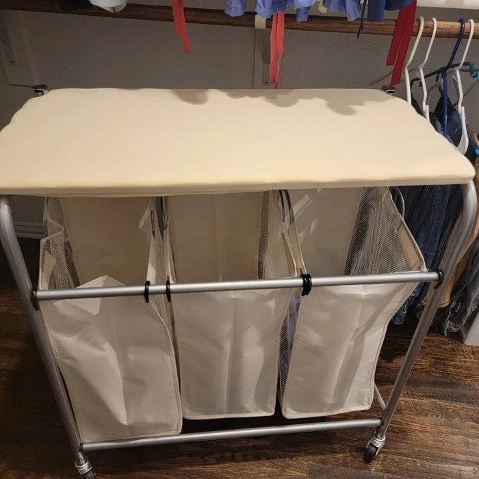 A three-basket hamper with an ironing board top