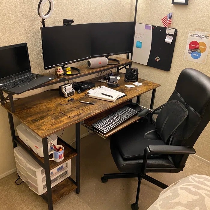 A two-tiered desk with black metal frame and wood desktops