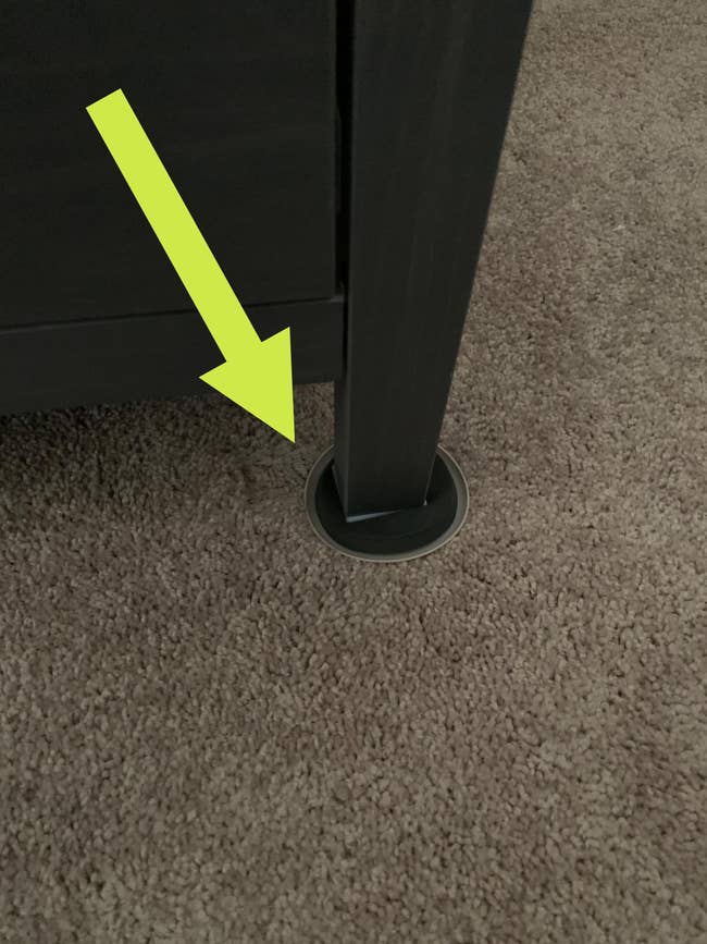 a reviewer photo of the slider underneath the leg of furniture