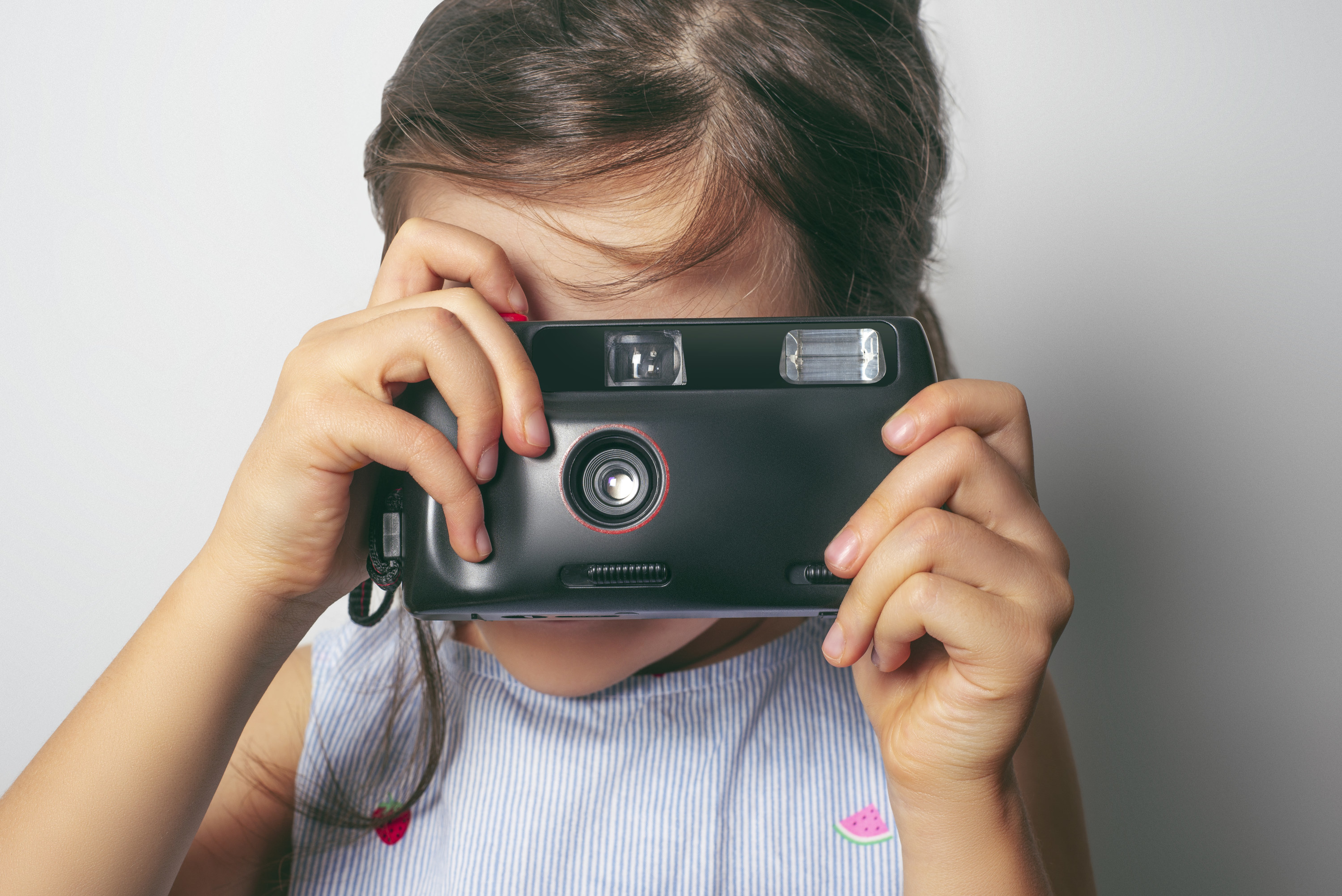 A cute girl taking photograph with a vintage film camera