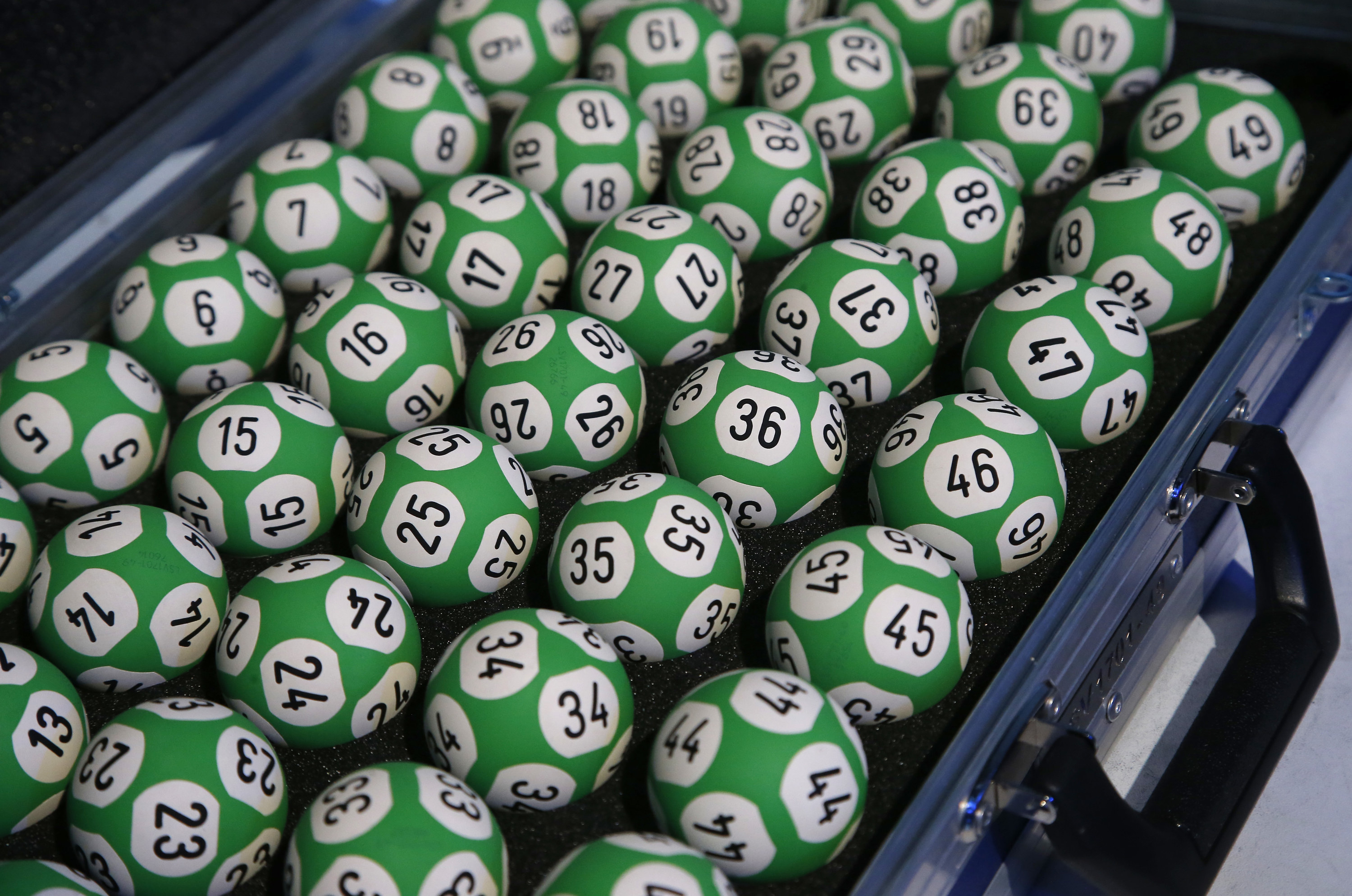 Lots of lottery balls with different numbers inside a suitcase