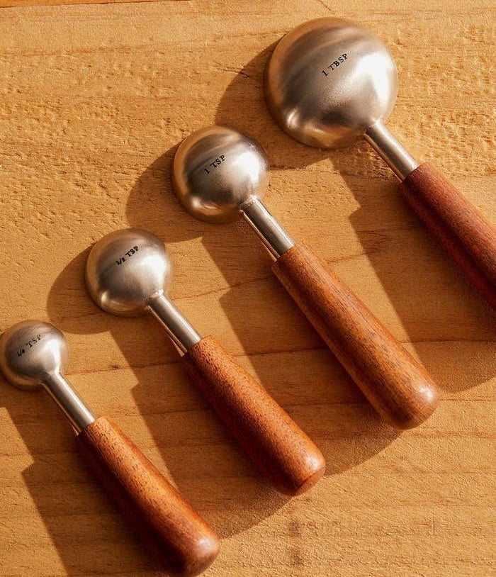 four measuring spoons with wooden handles