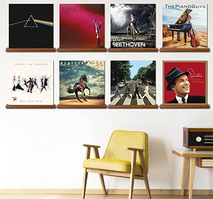 the shelves on a wall over a chair displaying different records