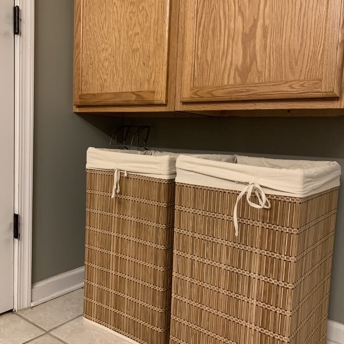 bamboo laundry hamper with lining next to a shoe rack