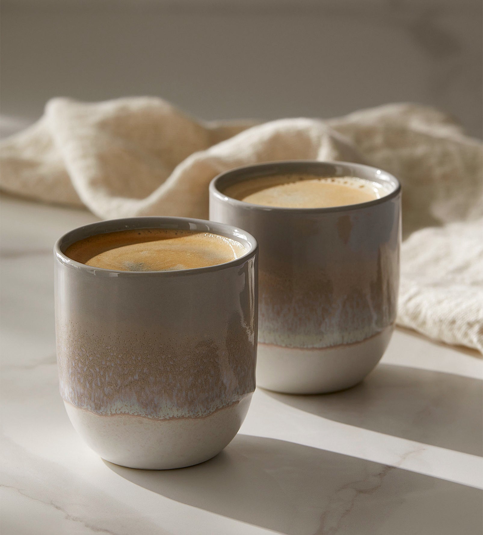 two mugs with coffee in each