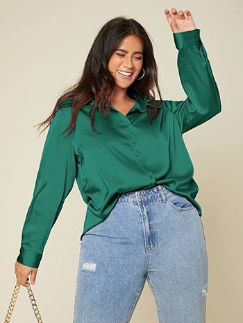 model wearing the dark green satin shirt with blue jeans